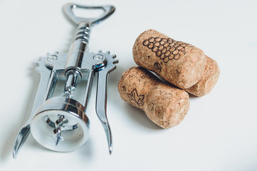 corkscrew with corks lies on a table-top