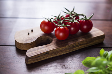 cocktail tomatoes and basil on wooden board