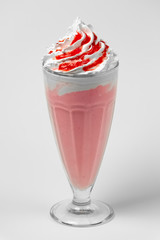 Glass of fruit cocktail with whipped cream on grey background