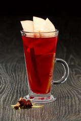 Glass of hot fruit tea on wooden table