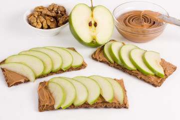 Sandwiches with peanut butter and an apple on the table close-up. Horizontal top view