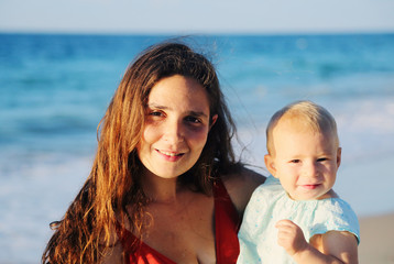 Fototapeta na wymiar Portrait of happy loving mother and her baby at the beach