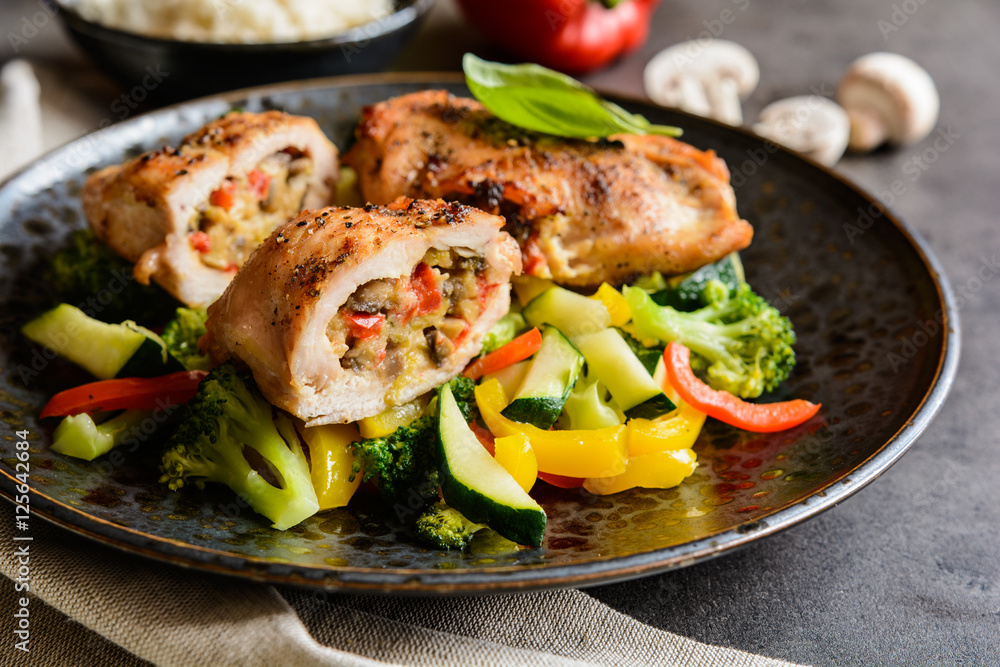 Wall mural Roasted chicken breasts stuffed with vegetable and sheep cheese, served with steamed vegetable and rice