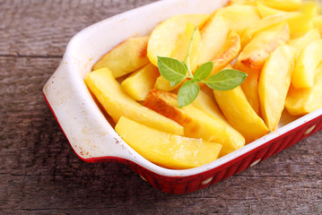 baked potato wedges on a wooden background
