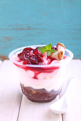 cheesecake with a cherry in a glass decorated with mint on a white and blue background