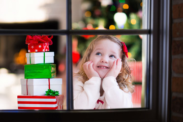 Child watching out of window on Christmas eve