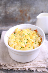 Cauliflower baked with cheese in a white bowl