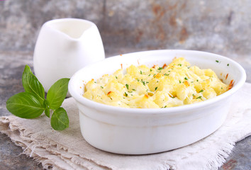 Cauliflower baked with cheese in a white bowl