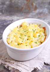 Cauliflower baked with cheese in a white bowl
