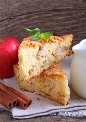 Charlotte with apples in the white plate on a wooden background