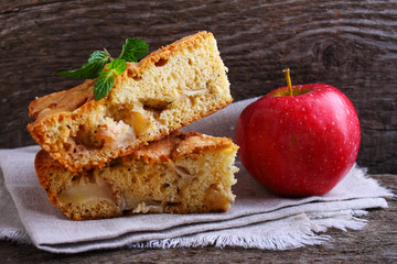 Charlotte with apples in the white plate on a wooden background