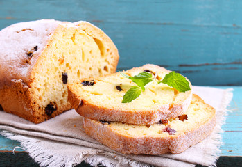 homemade cake with raisins and nuts cut into pieces on a blue background