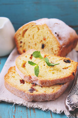 homemade cake with raisins and nuts cut into pieces on a blue background