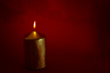 burning candle with dark red background
