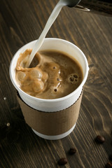 Cup of coffee which is poured on top of milk