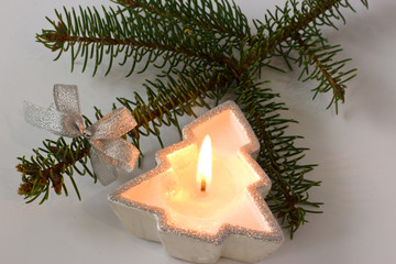Fur-tree branch and candle on a white background.