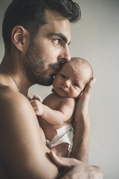 Portrait of loving father with baby at home. Sepia Toned