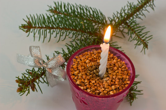 Fur-tree branch and candle on a white background.