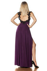 back view of pretty woman standing in a long dress with a deep slit