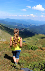 Naklejka premium The girl tourist (young woman) with long hair looks at the mount