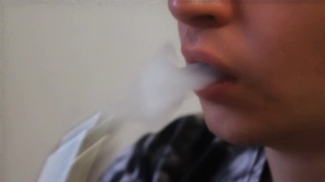 Man smoking electronic sigarette in the forest