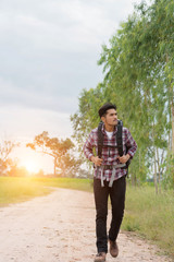 Young traveler hipster man walking on the road to adventure.