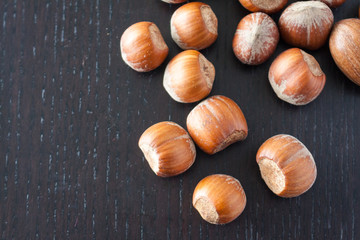 Overhead view of hazlenuts on a dark wooden surface