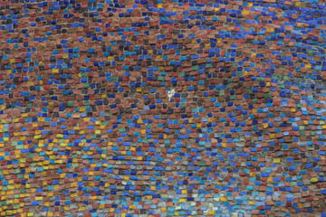 Wall decorated with mosaic tiles and colored bricks Photo execut