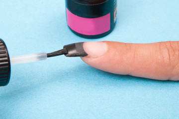 Manicure. Master make Art nail design. Finger closeup on a blue background. 
