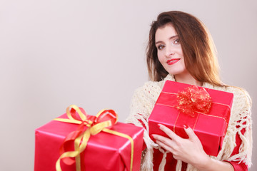 Woman holds red christmas gift boxes