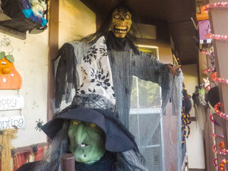 Outdoor house halloween decoration with monster and witch.