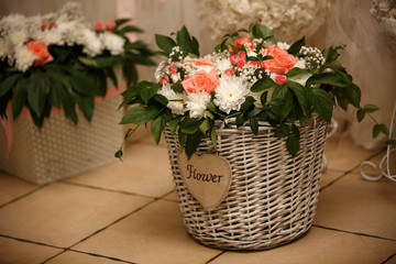 Composition of fresh flowers in the wooden jar