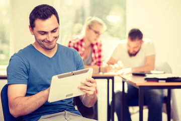 Male student with tablet in front of her classmates