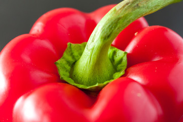 Close-up view of a ripe red bell pepper on a dark wooden background