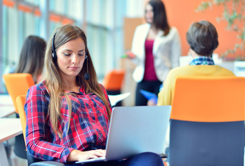 Cute businesswoman in an office with colleagues at the background