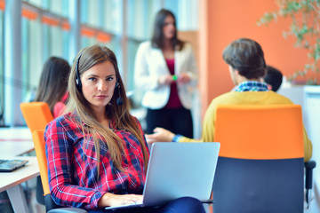 Cute businesswoman in an office with colleagues at the background