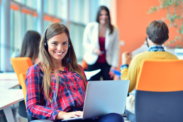 Cute businesswoman in an office with colleagues at the background