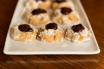 Chocolate Thumbprint Cookies on a White Platter, Wooden Table Top