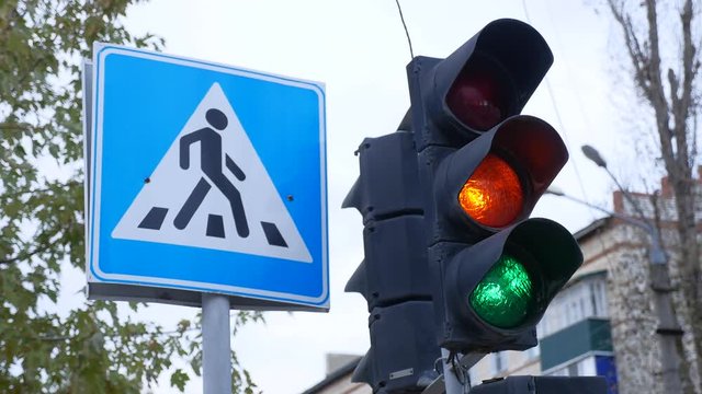 traffic light switches from green to red near the pedestrian crossing sign