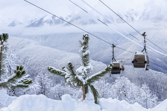 Cableway lift gondola cabins on winter snowy mountains background