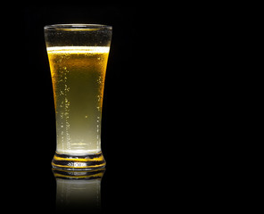 frosty light beer in clear glass with steam for winter drink or