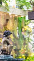 Obraz premium Statue of angel in cozy garden./ Statue of angel and waterfall in cozy garden on summer. 