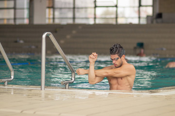 swimmer in pool water, stretching arms