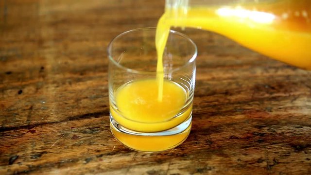 closeup of orange juice being poured in a glass
