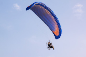 Paragliders flying with paramotor in the clear sky