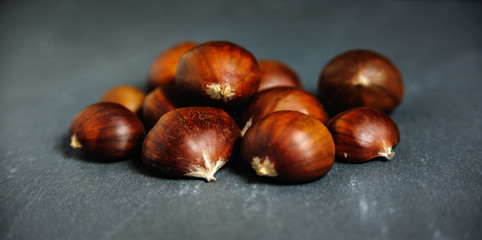 edible chestnuts close up on slate background