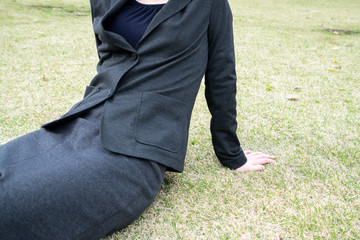 芝生に座るビジネスウーマン