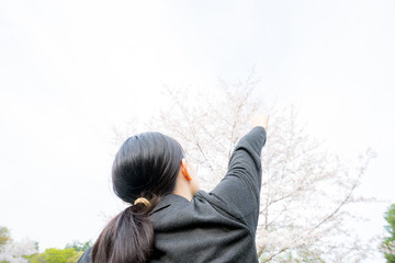 空に向かってガッツポーズするビジネスウーマン