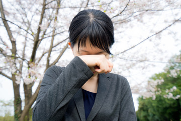 桜の下で泣くビジネスウーマン