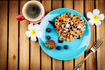 Cup of coffee and pastry on wooden background
